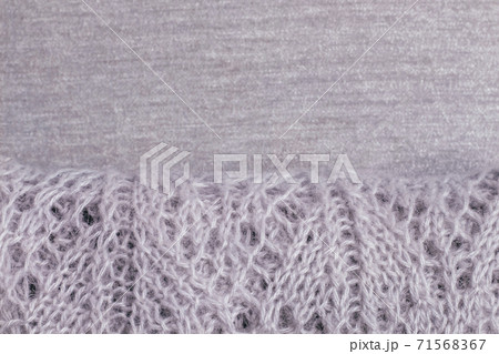 Knitted pastel colored sweater with visible pattern folded on velvety fabric. Top view, copy space. Knitted pastel colored sweater with visible pattern folded on velvety fabric. Top view, copy space. 71568367