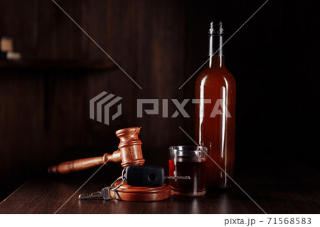 Car key, judge gavel and whiskey alcohol drink in a glass on a wooden table. Don't drink and drive abstract concept 71568583
