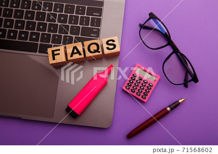 Wooden blocks with word FAQS on pink table. Frequently asked question 71568602