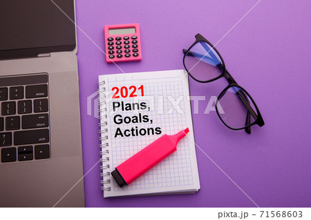 Plans, Goals and Actions 2021 - Business office desk with notebook written in handwriting about plan listing of goals and resolutions setting 71568603