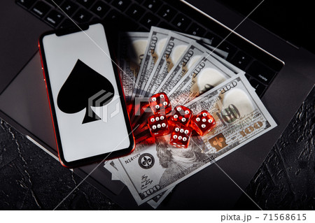 Dice, smartphone and dollar banknotes on keyboard. Gambling addiction and betting concept Dice, smartphone and dollar banknotes on keyboard. Gambling addiction and betting concept 71568615