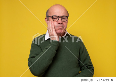 Hispanic man having a toothache against yellow background Hispanic man having a toothache against yellow background 71569916
