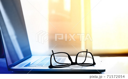 open laptop on which lie reading glasses in black frames open laptop on which lie reading glasses in black frames 71572054