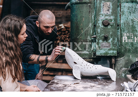 People carefully work on a ceramic whale in workshop People carefully work on a ceramic whale in workshop 71572157