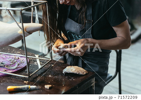 Portrait of young woman enjoying favorite job in workshop. Portrait of young woman enjoying favorite job in workshop. 71572209