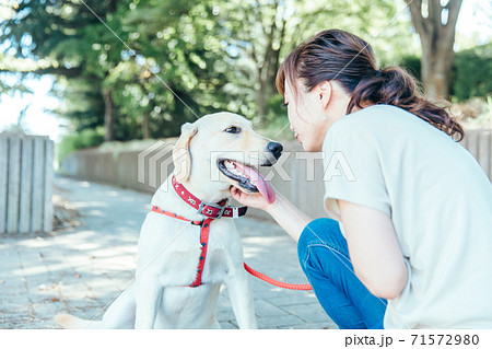 飼い主と散歩する犬 71572980