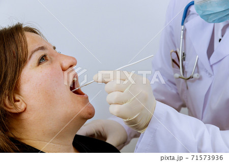 Medical worker to check in woman on mouth swab for PLR test coronavirus for Covid-19 71573936
