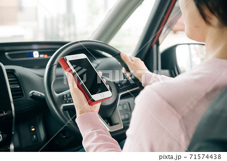 運転中にスマホ操作をする女性 71574438