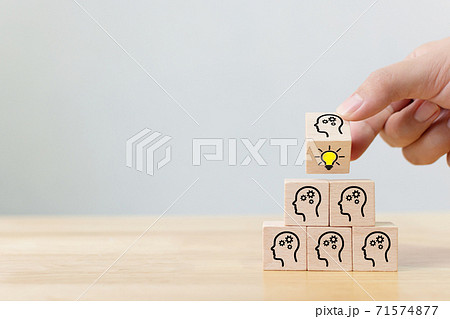 Hand flip over wooden cube block with head human symbol and light bulb icon Hand flip over wooden cube block with head human symbol and light bulb icon 71574877