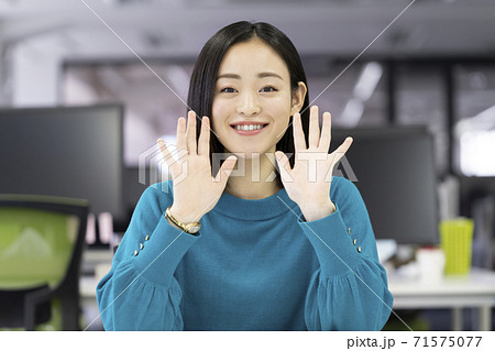 カメラに向かって手を振るの代前半の女性の写真素材