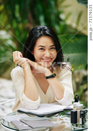 Lovely young woman sitting at table Lovely young woman sitting at table 71576135