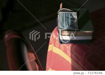 Face mask on top of stacked books on top of table 71576546