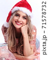 happy girl with santa hat lying between christmas ornaments 71578732