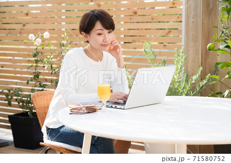 屋外でノートパソコンを見る女性 屋外でノートパソコンを見る女性 71580752