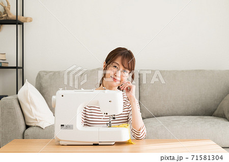 ミシンの前に座る眼鏡の女性 71581304