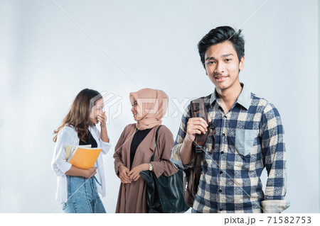 Portrait of Happy young man university carrying bags and campus young people chatting Portrait of Happy young man university carrying bags and campus young people chatting 71582753