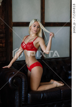 Sexy fashion model with blond hair, posing in bedroom, wearing red lingerie Sexy fashion model with blond hair, posing in bedroom, wearing red lingerie 71584818