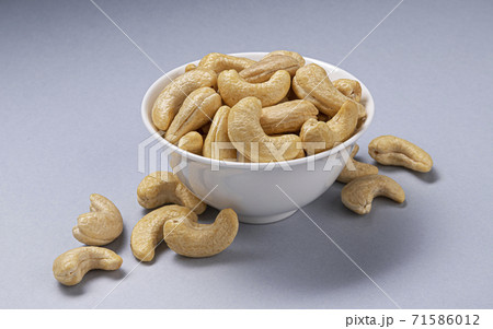 Heap of cashew nuts in bowl on white background Heap of cashew nuts in bowl on white background 71586012