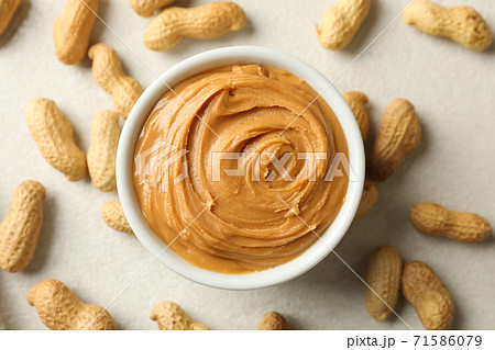 Bowl with peanut butter and peanut on white background Bowl with peanut butter and peanut on white background 71586079