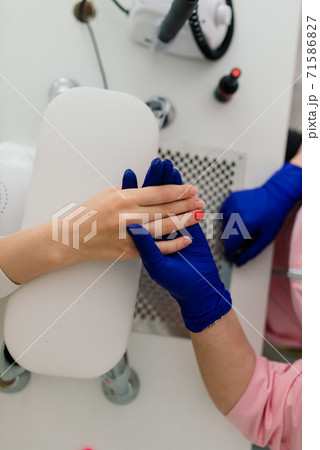 Female manicure master in a beauty salon work with hands of the client Female manicure master in a beauty salon work with hands of the client 71586827
