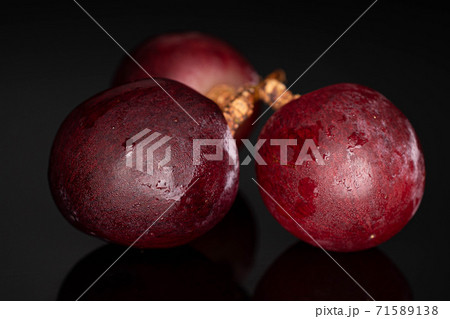 Red globe grape on black glass 71589138