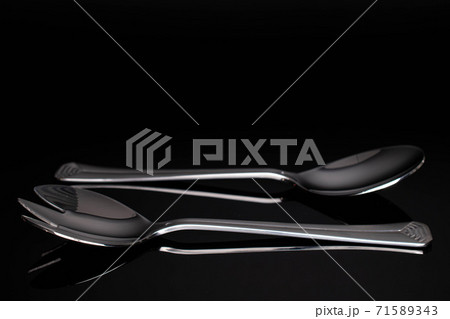 Steel cutlery on black glass 71589343