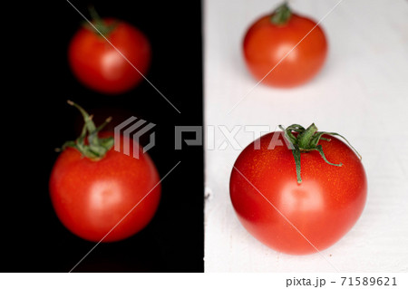 Cherry tomato on black glass Cherry tomato on black glass 71589621