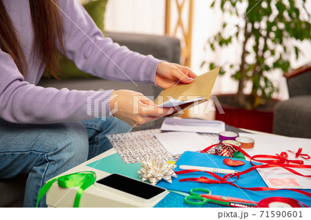 Woman making greeting card for New Year and Christmas 2021 for friends or family, scrap booking, DIY 71590601