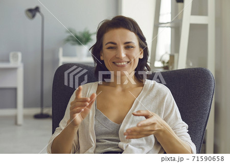 Smiling woman explaining something with hands during online meeting from home 71590658
