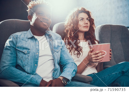 An African American man came with wife to cinema. 71590735