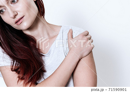 A woman holding on to her shoulder that hurts. A woman holding on to her shoulder that hurts. 71590901