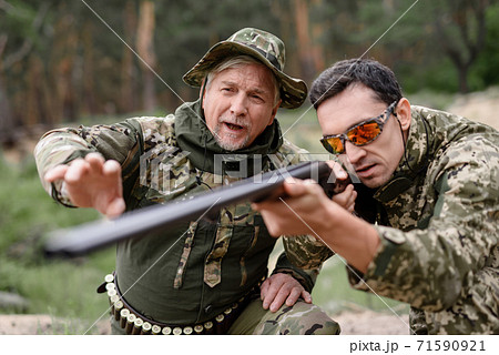 Hunters Shoot in Summer Forest with Shotgun. Hunters Shoot in Summer Forest with Shotgun. 71590921