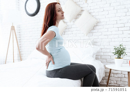 The woman has a pain in her back. The woman has a pain in her back. 71591051