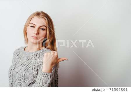 Pensive skeptical woman pointing on empty space Pensive skeptical woman pointing on empty space 71592391