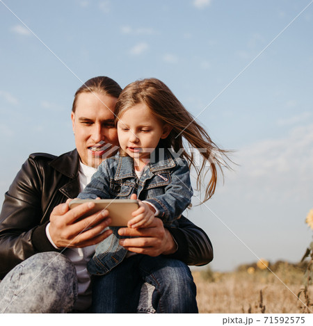 Father and daughter playing games with cell phone 71592575