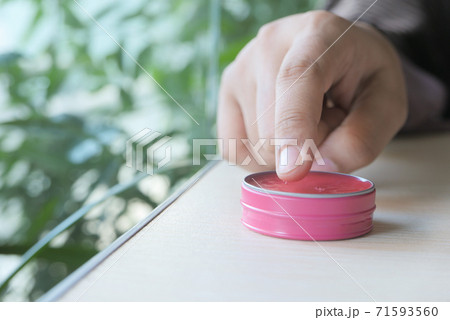 woman using petroleum jelly onto skin at home close up. 71593560