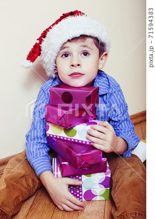 little cute boy with Christmas gifts at home wearing red Santas hat. closeup emotional happy smiling in mess with toys, lifestyle holiday people concept little cute boy with Christmas gifts at home wearing red Santas hat. closeup emotional happy smiling in mess with toys, lifestyle holiday people concept 71594383