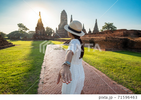 Tourist Woman in white dress holding her husband by hand and walking to ancient stupa in Wat Chaiwatthanaram temple in Ayutthaya Historical Park, summer, together, follow me, Asia and Thailand travel Tourist Woman in white dress holding her husband by hand and walking to ancient stupa in Wat Chaiwatthanaram temple in Ayutthaya Historical Park, summer, together, follow me, Asia and Thailand travel 71596463