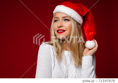 Pretty blonde lady in Santa Claus hat waiting for 71597676