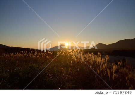 会津磐梯山に沈む最中の夕日に照らされるススキの原っぱ 会津磐梯山に沈む最中の夕日に照らされるススキの原っぱ 71597849