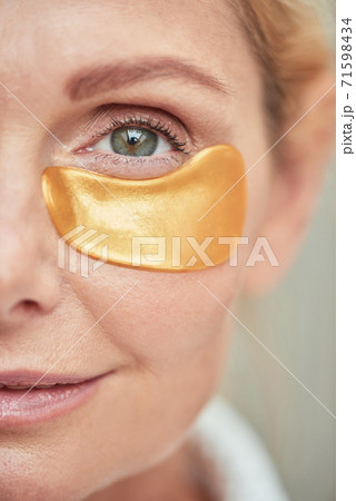 Middle aged caucasian woman half face with eye patch Middle aged caucasian woman half face with eye patch 71598434