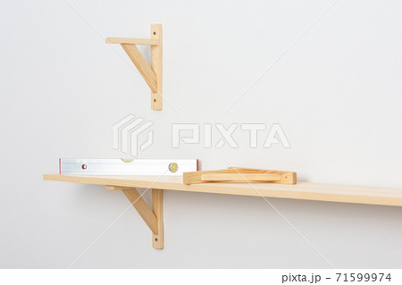 The process of attaching a wooden shelf to the wall 71599974
