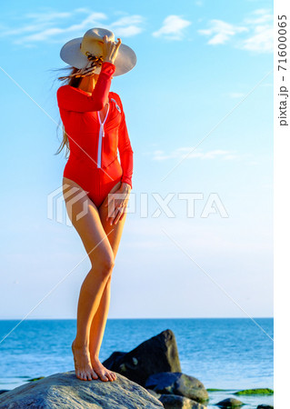 Slender woman in swimsuit at seaside in summer Slender woman in swimsuit at seaside in summer 71600065