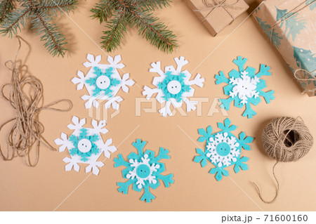 DIY instruction. Step by step tutorial. Making Xmas toy snowflake of felt. Step 5 - Stack all details to multilayer snowflakes. Top view, flat lay. DIY instruction. Step by step tutorial. Making Xmas toy snowflake of felt. Step 5 - Stack all details to multilayer snowflakes. Top view, flat lay. 71600160