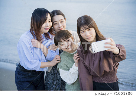 スマートフォンで記念撮影をする女性4人 スマートフォンで記念撮影をする女性4人 71601306