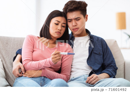 Frustrated Japanese Couple Holding Negative Pregnancy Test At Home 71601492