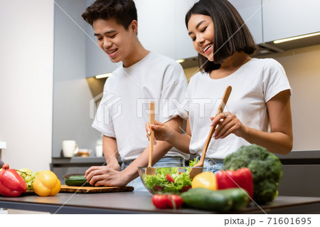 Couple Cooking Salad In Kitchen, Husband Helping Wife Prepare Dinner 71601695