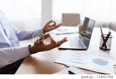 African american businessman meditating in office relaxing during work 71601708