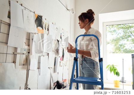 Girl standing on a stepladder Girl standing on a stepladder 71603253