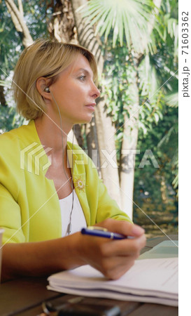 vertically. businesswoman holding video conference via laptop in an outdoor cafe vertically. businesswoman holding video conference via laptop in an outdoor cafe 71603362